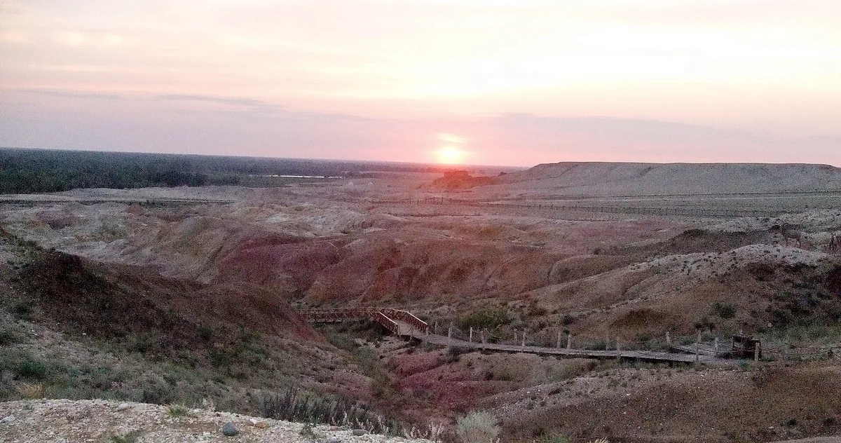 A photographed sunset adds warmth to Rainbow Beach’s coloured rock layers.