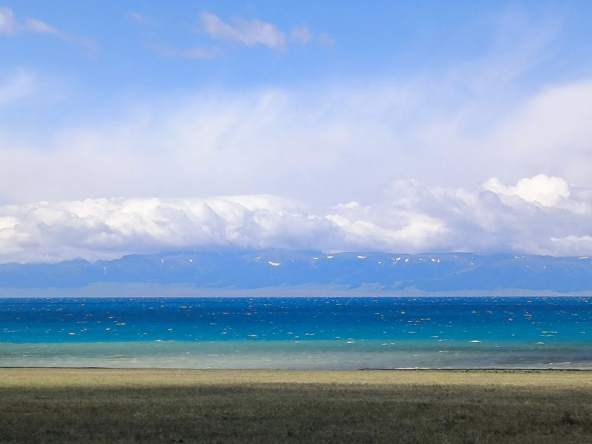 Layers of blue stretch across Sayram Lake towards the Tian Shan.