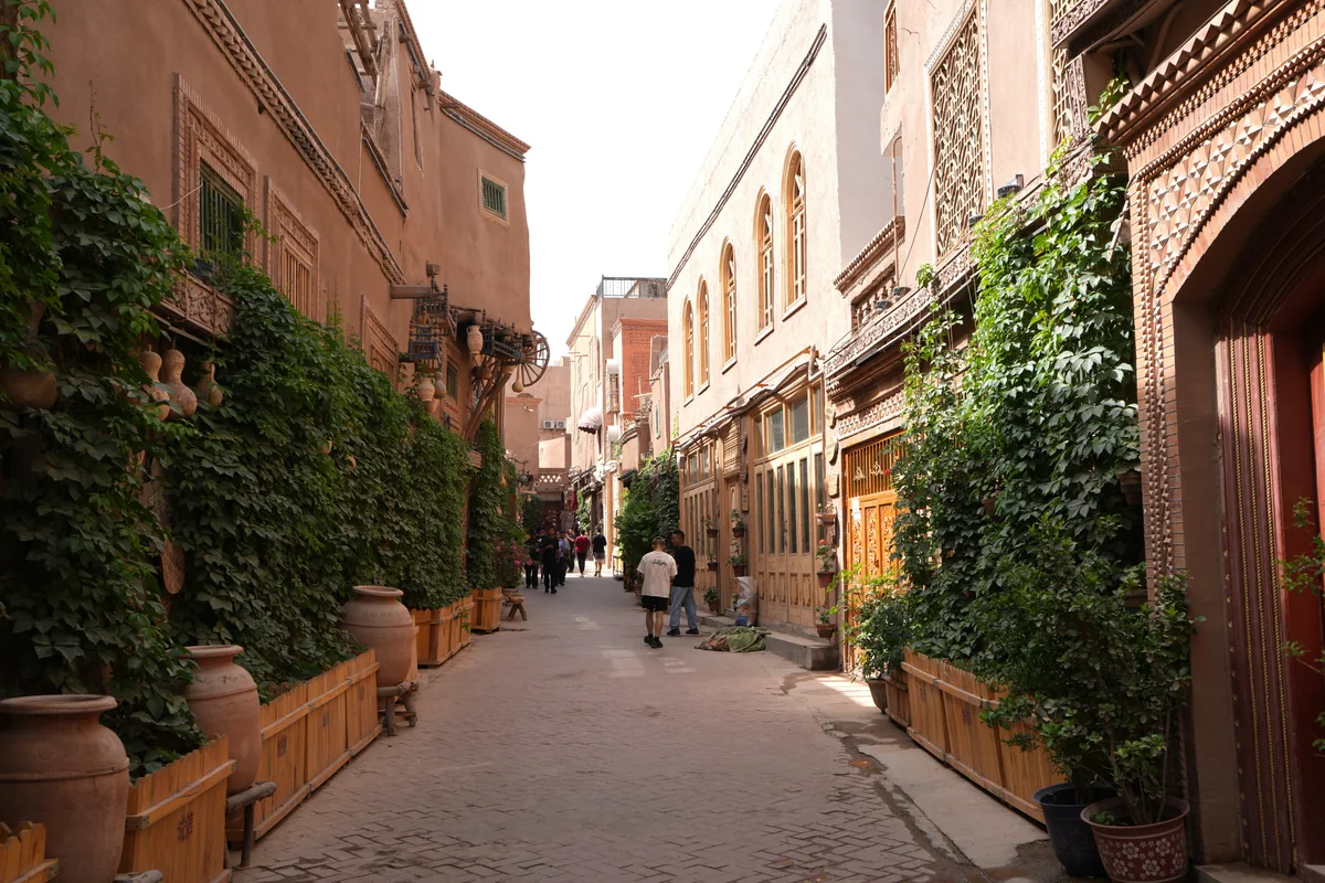 Warm walls and greenery line a quiet lane in Kashgar’s Old City.