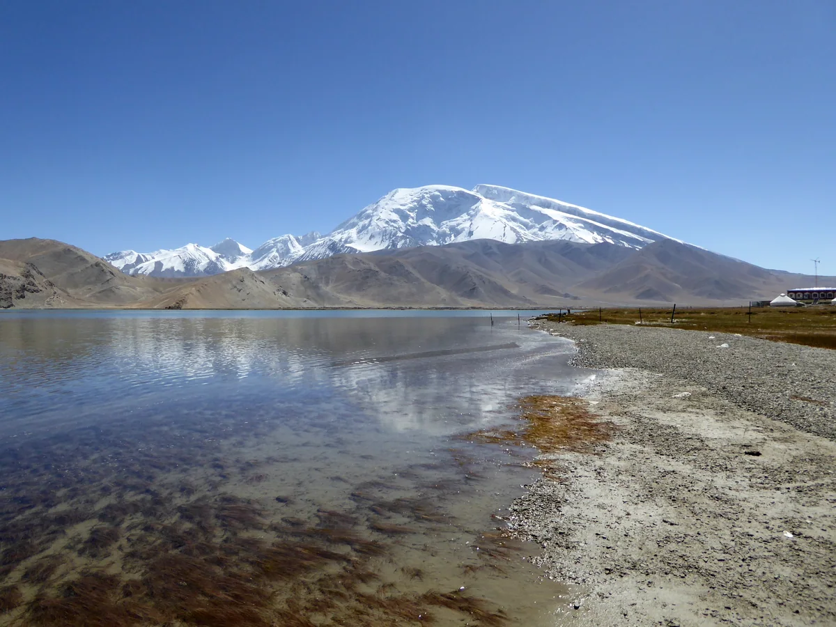 Muztagh Ata rises above the clear waters of Karakul Lake in Xinjiang.