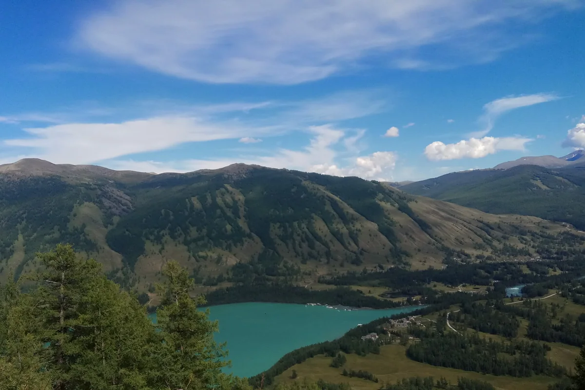 Forest and mountains frame the blue waters at Kanas Lake’s outlet.