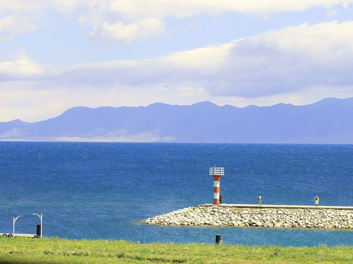 A lakeside lighthouse marks the meeting of water and sky at Sayram.