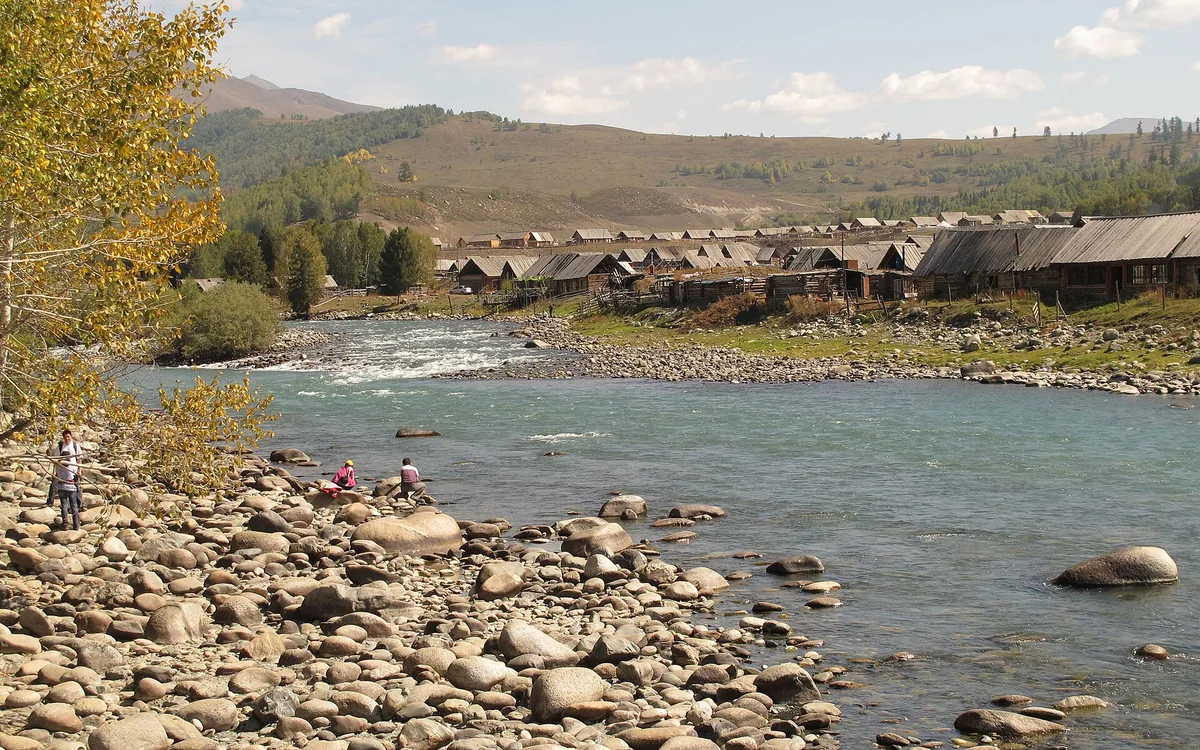 Hemu River and timber houses, edged with early golden foliage.
