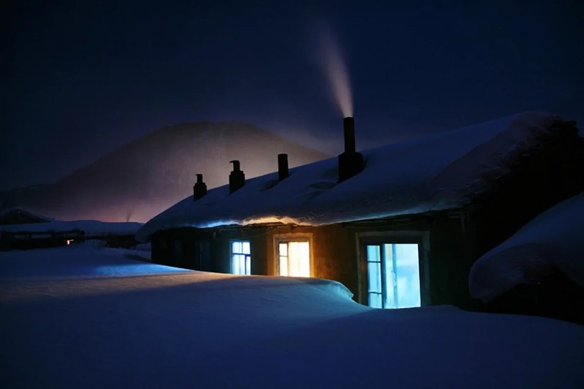 Beiji Village in winter · Snow-covered houses and warm window light