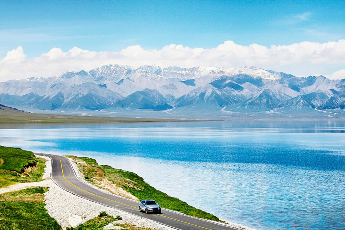 Sayram Lake · Snow peaks, blue water and the lakeside road